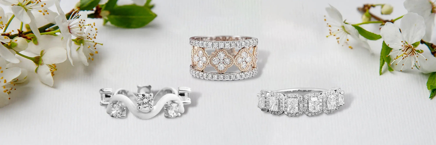Three designer lab-grown diamond bands in yellow gold — bold chunky pavé bar ring, triple stacked wide oval solitaire band, and curved chevron pavé band with fancy yellow diamond accents on grey cylinder pedestals